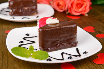 Sweet cake with chocolate on plate on table close-up