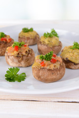 Stuffed mushrooms on plate on table on light background