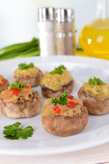 Stuffed mushrooms on plate on table on light background