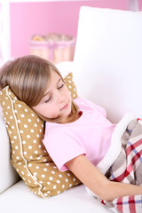 Naklejka premium Little girl sleeping on sofa in room