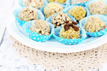 Set of chocolate candies, on plate, on wooden background