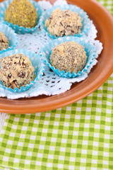 Set of chocolate candies, on plate, on wooden background