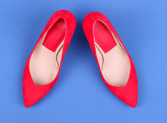 Beautiful red female shoes, on blue background