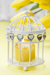 Bouquet of beautiful yellow tulips and candle in white vintage