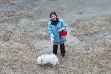ペットの犬と散歩をしている高齢の女性