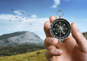 Man holding a compass over a landscape view © sergign