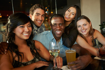 Group Of Friends Enjoying Drink At Bar Together