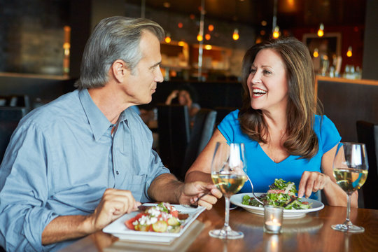 Mature Couple Enjoying Meal At Outdoor Restaurant