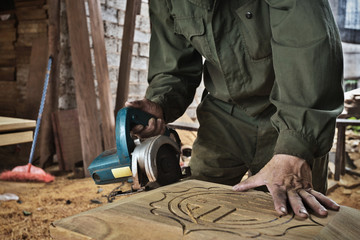 man cutting wood by machine