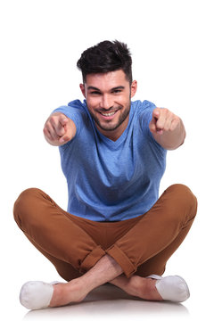 seated happy casual man pointing fingers