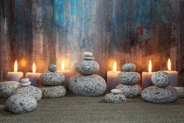 Steine und Kerzenschein vor abstraktem Gemälde