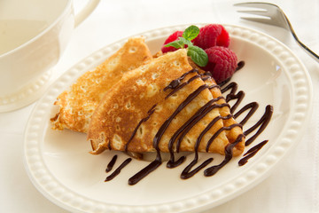Delicious pancakes with berries and chocolate sauce.