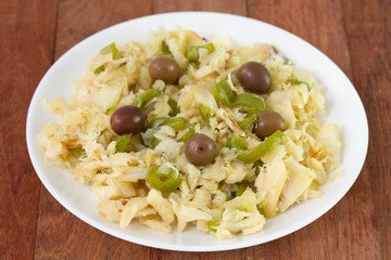 salad with codfish and vegetables on white plate