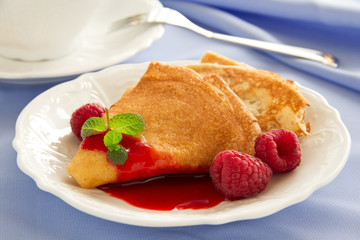 Delicious pancakes with berries  and raspberry sauce.