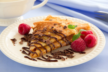 Delicious pancakes with berries and chocolate sauce.