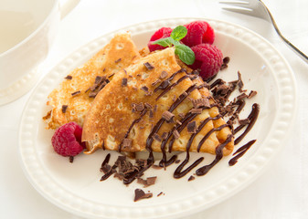 Delicious pancakes with berries and chocolate sauce.