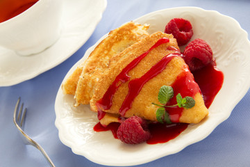Delicious pancakes with berries  and raspberry sauce.