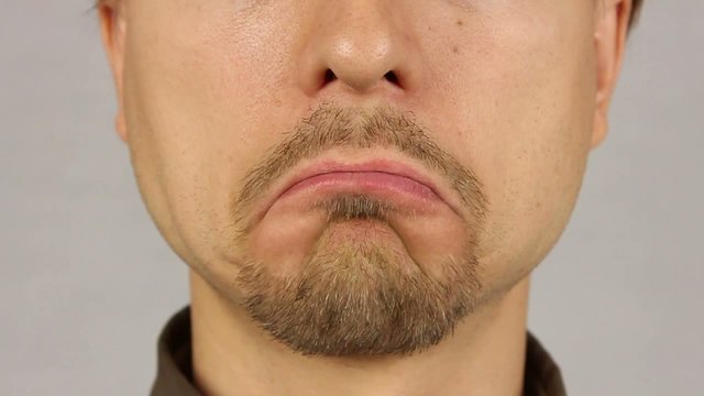 men's lips corners down, expressing sadness, closeup