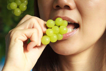 woman eating green grapes friut