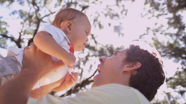 Loving Young Father Holding Baby Son High Outdoors 