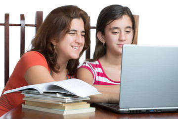 Hispanic teen and her mother working or browsing the web on a la