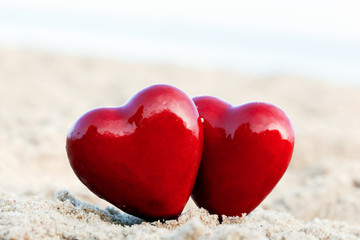 Two red hearts on the beach. Love, Valentine's Day, couple