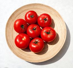 Спелые помидоры в деревянной тарелке