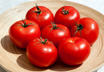 Спелые помидоры в деревянной тарелке