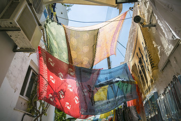 colored foulards hanging between houses in back lit