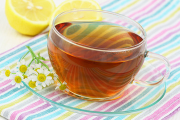 Tea, fresh chamomile flowers and lemon