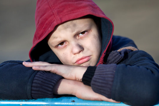 dramatic portrait of a little homeless boy