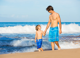 Happy father and son walking together at beach