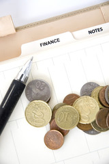 euro coins with pen on finance page