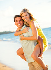 Attractive Couple Playing on the beach at Sunset