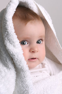 cute baby in a white towel after bathing