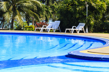 luxury swimming pool with sundeck white close up in tropical gar