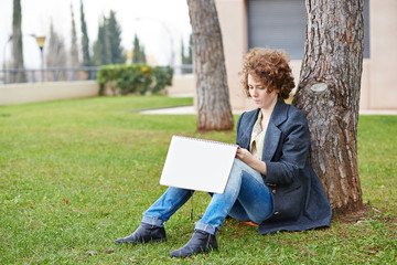 Fototapeta premium Female redhead art student drawing outdoors