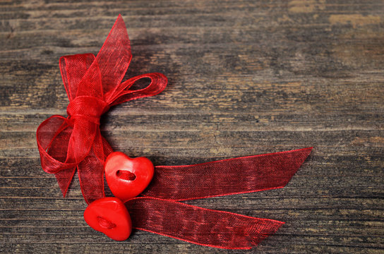 Two hearts tied red ribbon