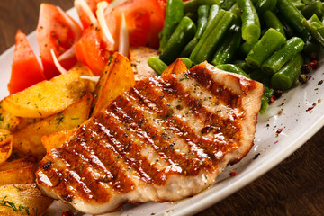 Grilled steak, baked potatoes and vegetables
