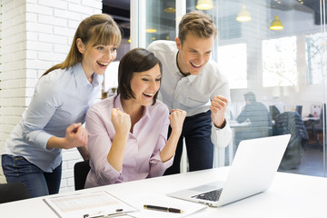 Happy Successful  business team in office, with arms up