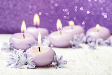 Fototapeta na wymiar Scented candles and hyacinth flowers on violet background