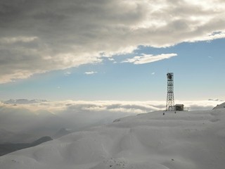 Obraz premium Transmitter on the peak of rock in mountains in ski resort