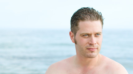 Fototapeta premium Attractive male portrait over sea background