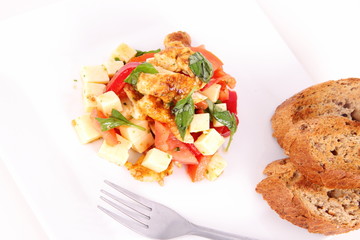Chicken, cheese & vegetable salad with some bread on a plat