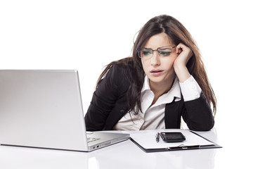 tired and sleepy young business woman at the desk with a laptop