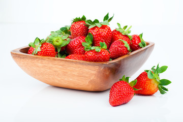 strawberry berry in wooden bowl, isolated on white background