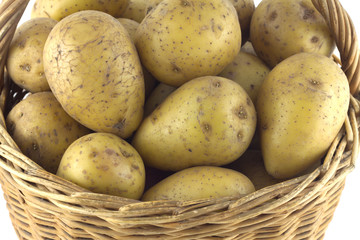 Ripe potatoes in brown wicker basket isolated closeup