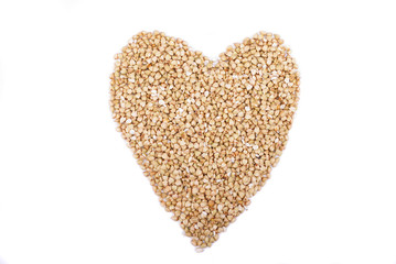 buckwheat groats in shape heart Isolated on white background