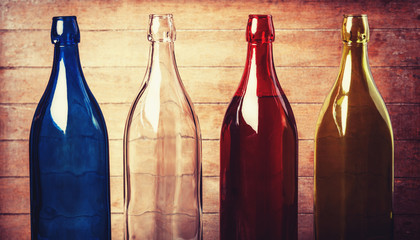 Four empty bottles of wine on wooden background