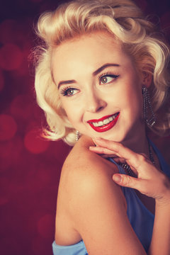 Pretty blond girl model like Marilyn Monroe on red background